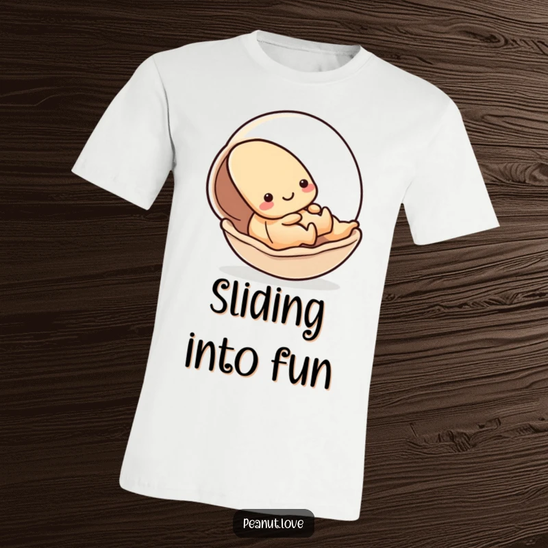 Funny t-shirt with a kawaii peanut character playfully sliding down a smooth shell, depicting energetic fun; a great gift.
